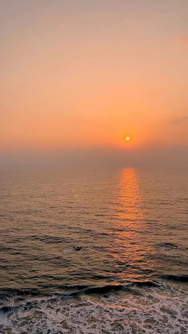 The sun setting into a calm sea